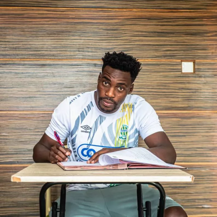 Malick Evouna signant son contrat avec Mangasport.