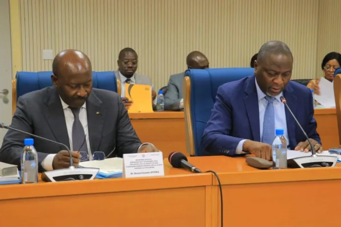 Devant la Commission des finances, le ministre d’État Henri-Claude Oyima (gauche) a défendu la réforme de la TFH comme un levier pour une fiscalité plus juste et pour l'amélioration des recettes budgétaires de l'État