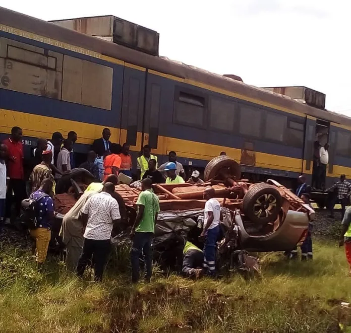 Riverains et passagers s'empressent de porter secours au conducteur du pick-up Mazda, coincé dans l'habitacle après l'impact avec le train express 410 au passage à niveau de Mbaya