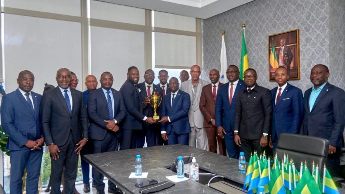 Luther Steeven Abouna Yangui, entouré des membres de l’AS Trésor Basket, lors de la présentation du trophée remporté à la 5ᵉ édition du tournoi « La Journée du Souvenir », le 12 mai 2026 à Libreville.