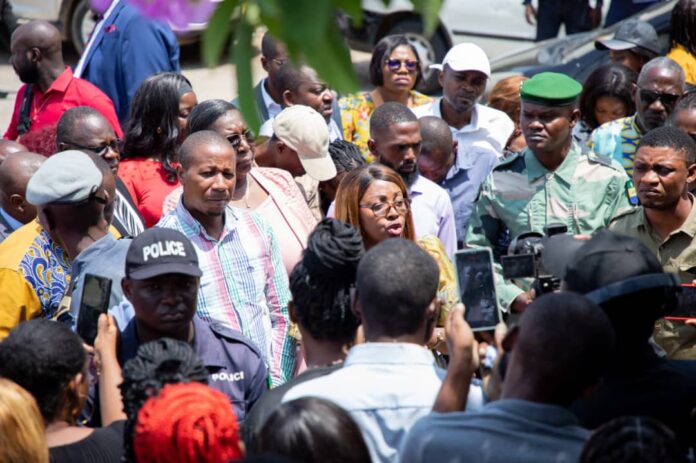 Ce 18 mai 2026, au milieu des membres du Mouvement national des volontaires rassemblés devant le ministère de la Fonction publique, la ministre Laurence Ndong échange directement avec les manifestants dans une démarche de pédagogie, d’écoute et d’apaisement autour de la question des postes budgétaires.