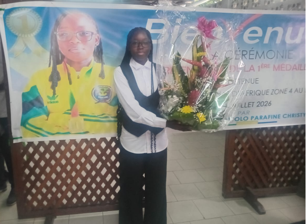 La championne d’Afrique Zone 4, Ay﻿ouma Mpolo Paraffine Christy, recevant un bouquet de fleurs lors de la cérémonie organisée en son honneur par sa famille, le samedi 25 juillet 2026, à l’Hôtel Louis, à Libreville.